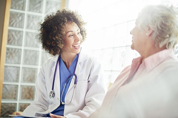 Female nurse practitioner consulting with elderly female patient.